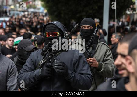 Djénine, Territoires palestiniens. 27 mars 2024. Des personnes armées participent aux funérailles de Palestiniens tués lors d'une opération de l'armée israélienne dans le camp de Djénine en Cisjordanie. Trois personnes ont été tuées, a rapporté l’armée israélienne. Crédit : Ayman Nobani/dpa/Alamy Live News Banque D'Images