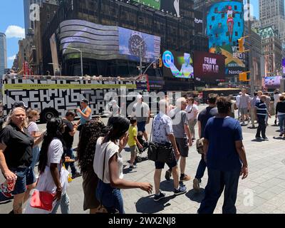 Par une journée d'été ensoleillée, les piétons traversent la rue à Times Square à New York Banque D'Images