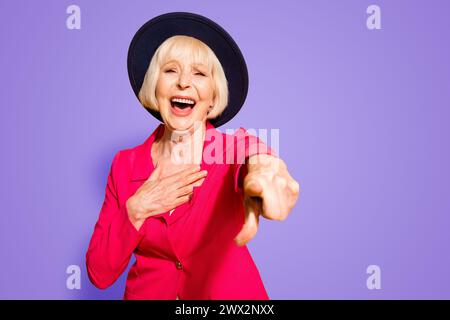 Eh bien, vous êtes un joker Granny pointant des index vers l'appareil photo et rires dehors fort isolé sur fond jaune vif Banque D'Images