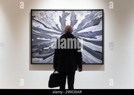 Londres, Royaume-Uni. 26 mars 2024. Un homme regarde de plus près une grande impression de l'artiste photographe Edward Burtynsky à la Saatchi Gallery, Londres. Il fait partie de l'exposition extraction / abstraction qui est la plus grande exposition jamais montée dans la carrière de plus de 40 ans du photographe de renommée mondiale. Crédit : Katie Collins/EMPICS/Alamy Live News USAGE ÉDITORIAL UNIQUEMENT Banque D'Images