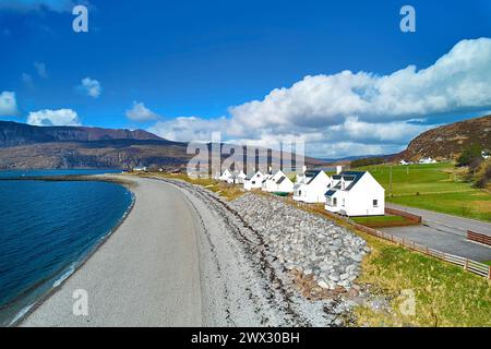 Ardmair Wester Ross Écosse ciel bleu les maisons de vacances blanches de plage de galets gris et Ben Mor Coigach au loin Banque D'Images