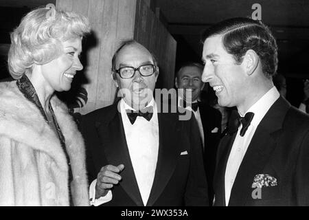 Dossier photo datée du 14/11/79 du Prince de Galles (aujourd'hui Roi Charles III), célébrant son 31e anniversaire, échangeant des blagues avec le comédien Eric Morecambe (au centre) et son épouse Joan, au Centre de conférences de Wembley. Joan, veuve d'Eric Morecambe, est décédée 'paisiblement' le jour de son 97e anniversaire suite à une courte maladie, a annoncé sa famille. Elle épouse le célèbre comédien, connu pour son double acte Morecambe et Wise aux côtés d'Ernie Wise, à Margate en 1952. Date d'émission : mercredi 27 mars 2024. Banque D'Images