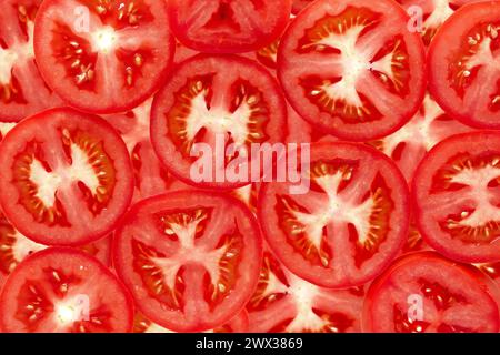 Tranches de tomates rouges juteuses, graines de chair et textures. Fond alimentaire naturel sain Banque D'Images