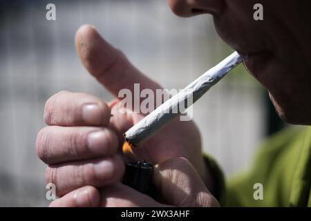 Berlin, Allemagne. 27 mars 2024. Un homme fume un joint. Le 22 mars 2024, le Conseil fédéral a ouvert la voie à la légalisation partielle du cannabis le 1er avril. Crédit : Sebastian Gollnow/dpa/Alamy Live News Banque D'Images