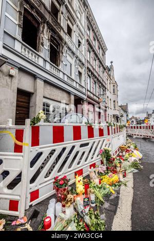 Wuppertal, Allemagne. 27 mars 2024. Des fleurs et des bougies se trouvent devant la scène de l'incendie à Solingen après le communiqué de presse du parquet de Wuppertal sur l'incendie mortel à Solingen. Quatre personnes sont mortes dans l'incendie lundi matin et plusieurs ont été blessées. Crédit : Christoph Reichwein/dpa/Alamy Live News Banque D'Images