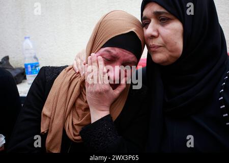 Jénine, Palestine. 27 mars 2024. Des proches pleurent lors des funérailles de 3 Palestiniens tués par les balles des forces israéliennes lors d'un raid sur le quartier de Damj dans le camp de Djénine en Cisjordanie occupée. Crédit : SOPA images Limited/Alamy Live News Banque D'Images