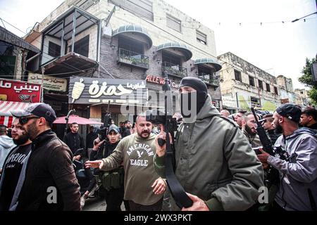 Jénine, Palestine. 27 mars 2024. Des hommes armés participent aux funérailles de 3 jeunes Palestiniens tués par les balles des forces israéliennes lors d'un raid sur le quartier de Damj dans le camp de Djénine en Cisjordanie occupée. (Photo de Nasser Ishtayeh/SOPA images/Sipa USA) crédit : Sipa USA/Alamy Live News Banque D'Images