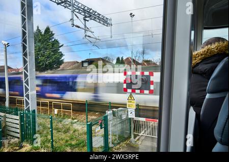 Train roulant à vitesse excessive passant au-dessus du passage à niveau vu du pont supérieur de l'autobus Banque D'Images