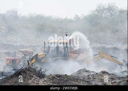 Noida, Inde. 27 mars 2024. NOIDA, INDE - MARS 27 : les pompiers tentent d'éteindre un incendie dans un dépôt de déchets horticoles dans le secteur 32 le 27 mars 2024 à Noida, en Inde. Le feu a commencé vers 18 heures lundi et a englouti une zone d'environ 1,5 km de large et 2 km de long dans le secteur 32, a déclaré le chef des pompiers de GB Nagar. Tous les déchets horticoles de partout à Noida sont déversés sur cette parcelle pour être convertis en compost. (Photo de Sunil Ghosh/Hindustan Times/Sipa USA) crédit : Sipa USA/Alamy Live News Banque D'Images