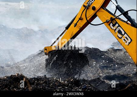 Noida, Inde. 27 mars 2024. NOIDA, INDE - MARS 27 : les pompiers tentent d'éteindre un incendie dans un dépôt de déchets horticoles dans le secteur 32 le 27 mars 2024 à Noida, en Inde. Le feu a commencé vers 18 heures lundi et a englouti une zone d'environ 1,5 km de large et 2 km de long dans le secteur 32, a déclaré le chef des pompiers de GB Nagar. Tous les déchets horticoles de partout à Noida sont déversés sur cette parcelle pour être convertis en compost. (Photo de Sunil Ghosh/Hindustan Times/Sipa USA) crédit : Sipa USA/Alamy Live News Banque D'Images