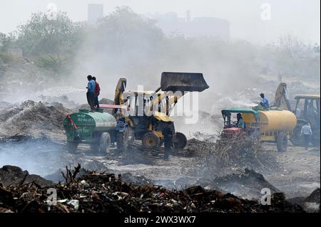 Noida, Inde. 27 mars 2024. NOIDA, INDE - MARS 27 : les pompiers tentent d'éteindre un incendie dans un dépôt de déchets horticoles dans le secteur 32 le 27 mars 2024 à Noida, en Inde. Le feu a commencé vers 18 heures lundi et a englouti une zone d'environ 1,5 km de large et 2 km de long dans le secteur 32, a déclaré le chef des pompiers de GB Nagar. Tous les déchets horticoles de partout à Noida sont déversés sur cette parcelle pour être convertis en compost. (Photo de Sunil Ghosh/Hindustan Times/Sipa USA) crédit : Sipa USA/Alamy Live News Banque D'Images