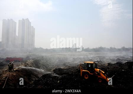 Noida, Inde. 27 mars 2024. NOIDA, INDE - MARS 27 : les pompiers tentent d'éteindre un incendie dans un dépôt de déchets horticoles dans le secteur 32 le 27 mars 2024 à Noida, en Inde. Le feu a commencé vers 18 heures lundi et a englouti une zone d'environ 1,5 km de large et 2 km de long dans le secteur 32, a déclaré le chef des pompiers de GB Nagar. Tous les déchets horticoles de partout à Noida sont déversés sur cette parcelle pour être convertis en compost. (Photo de Sunil Ghosh/Hindustan Times/Sipa USA) crédit : Sipa USA/Alamy Live News Banque D'Images