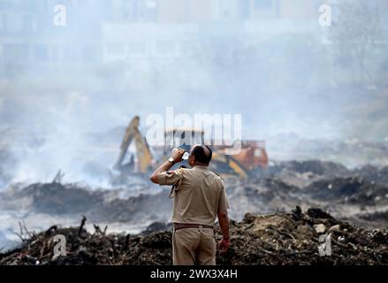 Noida, Inde. 27 mars 2024. NOIDA, INDE - MARS 27 : les pompiers tentent d'éteindre un incendie dans un dépôt de déchets horticoles dans le secteur 32 le 27 mars 2024 à Noida, en Inde. Le feu a commencé vers 18 heures lundi et a englouti une zone d'environ 1,5 km de large et 2 km de long dans le secteur 32, a déclaré le chef des pompiers de GB Nagar. Tous les déchets horticoles de partout à Noida sont déversés sur cette parcelle pour être convertis en compost. (Photo de Sunil Ghosh/Hindustan Times/Sipa USA) crédit : Sipa USA/Alamy Live News Banque D'Images