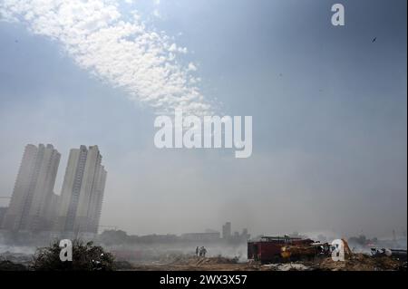 Noida, Inde. 27 mars 2024. NOIDA, INDE - MARS 27 : les pompiers tentent d'éteindre un incendie dans un dépôt de déchets horticoles dans le secteur 32 le 27 mars 2024 à Noida, en Inde. Le feu a commencé vers 18 heures lundi et a englouti une zone d'environ 1,5 km de large et 2 km de long dans le secteur 32, a déclaré le chef des pompiers de GB Nagar. Tous les déchets horticoles de partout à Noida sont déversés sur cette parcelle pour être convertis en compost. (Photo de Sunil Ghosh/Hindustan Times/Sipa USA) crédit : Sipa USA/Alamy Live News Banque D'Images