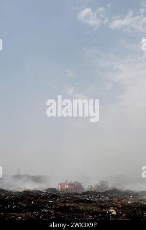 Noida, Inde. 27 mars 2024. NOIDA, INDE - MARS 27 : les pompiers tentent d'éteindre un incendie dans un dépôt de déchets horticoles dans le secteur 32 le 27 mars 2024 à Noida, en Inde. Le feu a commencé vers 18 heures lundi et a englouti une zone d'environ 1,5 km de large et 2 km de long dans le secteur 32, a déclaré le chef des pompiers de GB Nagar. Tous les déchets horticoles de partout à Noida sont déversés sur cette parcelle pour être convertis en compost. (Photo de Sunil Ghosh/Hindustan Times/Sipa USA) crédit : Sipa USA/Alamy Live News Banque D'Images