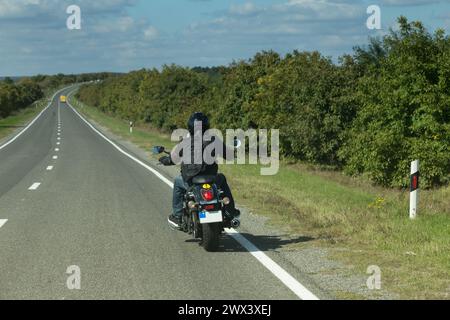 Vue arrière d'un motard dans une route. C'est un très beau paysage. Banque D'Images