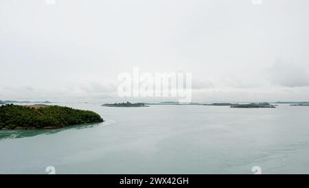 Des groupes de petites îles étendues à l'horizon lointain, avec une mer calme et un ciel sombre. Vue depuis le sommet du pont Barelang, Indonésie. Banque D'Images