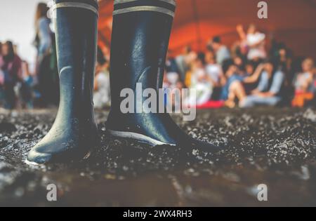 Bottes en caoutchouc dans la boue lors d'Un festival de musique, avec Copy Space Banque D'Images