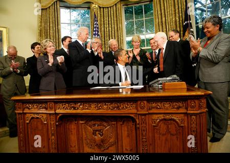 Washington, États-Unis d'Amérique. 17 juin 2009. Washington, DC - 17 juin 2009 -- le président américain Barack Obama tend la plume qu'il vient d'utiliser pour signer un mémorandum présidentiel concernant les avantages fédéraux et la non-discrimination dans le bureau ovale de la Maison Blanche au militant des droits des homosexuels Frank Kameny, Washington DC, mercredi 17 juin 2009. Derrière lui se trouvent le vice-président Joe Biden (5e l), le représentant américain Barney Frank (6e l) et le sénateur américain Joe Lieberman (7e l). Crédit : Aude Guerrucci - piscine via CNP/Sipa USA crédit : Sipa USA/Alamy Live News Banque D'Images