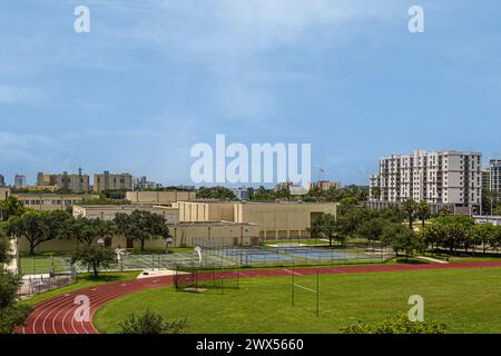 Miami, Floride, États-Unis - 29 juillet 2023 : Booker T. Washington Senior High School terrains de sport et bâtiments sous ciel bleu. Prog Martins place appartements Banque D'Images