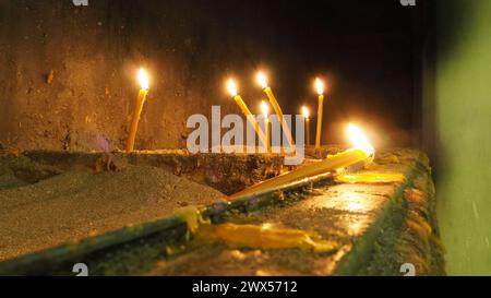 De grandes et longues bougies de cire brûlent pour le repos. Memorial Day avec bougie. Bougies commémoratives. Des flammes de bougie brûlent dans le cimetière. Bougies allumées dans le Banque D'Images