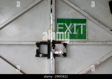 Porte en métal peint blanc utilisée pour l'entrée et la sortie avec panneau de SORTIE dans un chantier de construction de bâtiment. Banque D'Images