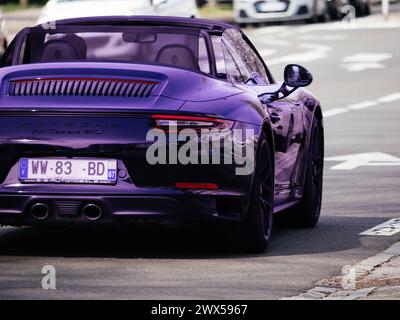 Haguenau, France - 20 mars 2024 : une Porsche 911 Carrera GTS violette se démarque dans les rues de Haguenau, mettant en valeur le luxe et la performance Banque D'Images