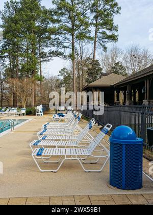 Terrasse de la piscine avec chaises longues alignées en attente des foules estivales à une grande piscine dans une communauté résidentielle à Pike Road Alabama, États-Unis. Banque D'Images