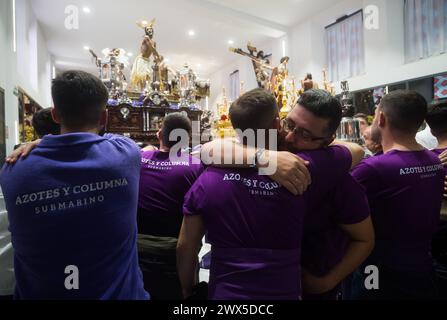 Deux pénitents de la fraternité Fusionadas sont vus embrassés devant la statue du Christ, après que la procession ait été suspendue en raison de la pluie, pendant le mercredi Saint, pour marquer les célébrations de la semaine Sainte. Des milliers de fidèles attendent pour voir les processions avec les statues du Christ et de la Vierge Marie dans le cadre des célébrations traditionnelles de la semaine Sainte. En Andalousie, Pâques rassemble des milliers de personnes du monde entier et est considérée comme l'un des événements religieux et culturels les plus importants de l'année. (Photo de Jesus Merida/SOPA images/SIPA USA) Banque D'Images