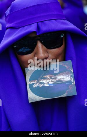 Antigua, Guatemala. 27 mars 2024. Un pénitent portant des lunettes de soleil et ses robes bleues attend le flotteur processionnel Jesús Nazareno del Milagro pendant la traditionnelle Santa Semana célébrant la semaine Sainte, le 27 mars 2024 à Antigua, Guatemala. Les processions opulentes, les algèbres détaillées et les traditions séculaires attirent plus d'un million de personnes dans l'ancienne capitale. Crédit : Richard Ellis/Richard Ellis/Alamy Live News Banque D'Images