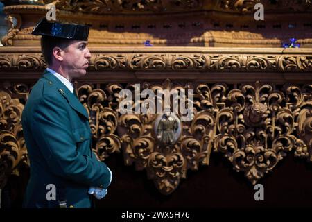 Madrid, Espagne. 27 mars 2024. Un agent de la Garde civile d'Espagne accompagne l'image du Père Jésus de la Salud lors de la procession appelée les Tsiganes à travers les rues du centre de Madrid. Dans la nuit du mercredi Saint dans les rues de Madrid, l’image de notre Père Jésus de la santé, de l’église El Carmen, est sortie en procession. Crédit : SOPA images Limited/Alamy Live News Banque D'Images