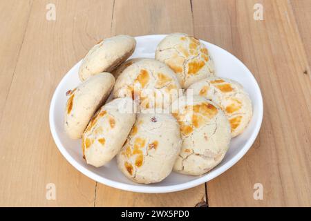 Biscuits Kulcha e khataye dans une assiette blanche avec un fond en bois Banque D'Images