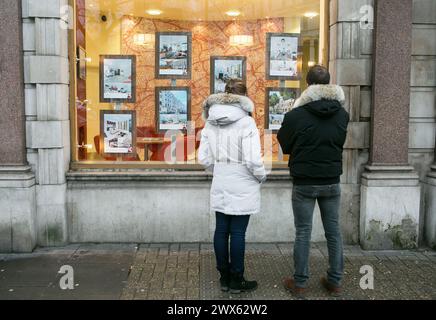 Photo du dossier datée du 04/12/14 de membres du public regardant dans la fenêtre d'un agent immobilier à South Kensington, Londres. Les vendeurs de maisons rasent généralement 10 000 £ de leur prix initial demandé pour réaliser une vente, selon un site Web de propriété. Au Royaume-Uni, l'escompte moyen de 3,9% enregistré en mars est une «amélioration marquée» par rapport à un escompte moyen de 14 250 £ ou 4,5% enregistré en novembre 2023, a déclaré Zoopla. Date d'émission : jeudi 28 mars 2024. Banque D'Images