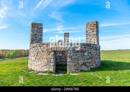 Une structure en pierre debout à Horni Slavkov, qui a historiquement servi de terrain d'exécution, posée contre un ciel bleu clair et un champ ouvert. Tchéquie Banque D'Images