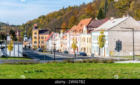 Une vue sereine sur la rue principale Horni Slavkovs bordée de bâtiments colorés et de feuillage d'automne doré, sous un ciel bleu clair. Tchéquie Banque D'Images