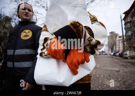 Volontaire ukrainien transportant des sacs poubelles sur le site de la frappe aérienne russe pour aider à nettoyer les décombres. Kiev - 23 mars 2024 Banque D'Images