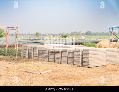 Planches de dalles dures en béton préfabriqué empilées sur le chantier de construction. Banque D'Images