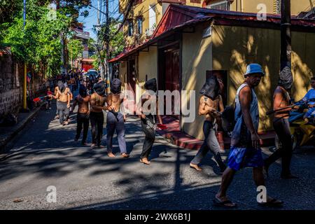 Mandaluyong City, Philippines. 28 mars 2024. Les flagellants philippins marchent le long d'une rue dans la ville de Mandaluyong. Beaucoup de dévots catholiques philippins passent leur semaine Sainte en faisant différentes formes de pénitence physique pour se repentir de leurs péchés. Crédit : SOPA images Limited/Alamy Live News Banque D'Images