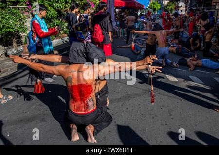 Mandaluyong City, Philippines. 28 mars 2024. Les pénitents philippins participent à l'auto-flagellation le jeudi Saint. Beaucoup de dévots catholiques philippins passent leur semaine Sainte en faisant différentes formes de pénitence physique pour se repentir de leurs péchés. Crédit : SOPA images Limited/Alamy Live News Banque D'Images