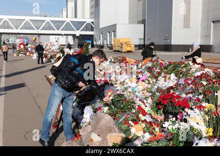 Moscou, Russie. 28 mars 2024. Un homme dépose des fleurs pour pleurer les victimes d'une attaque terroriste près de l'hôtel de ville de Crocus dans la banlieue de Moscou, en Russie, le 28 mars 2024. Le nombre de morts de l'attaque terroriste de vendredi a augmenté à 143 après que des hommes armés ont pris d'assaut une salle de concert dans la banlieue de Moscou, selon une liste publiée mercredi par le ministère russe des situations d'urgence. Crédit : Bai Xueqi/Xinhua/Alamy Live News Banque D'Images