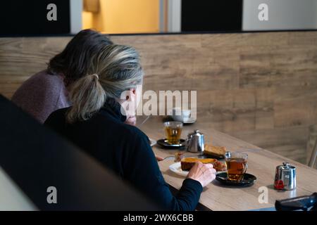 Deux femmes mangeant des torrijas dans une cafétéria pendant la semaine Sainte en Espagne Banque D'Images