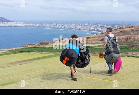 Deux parapentes transportant des sacs à dos et des parapentes à la zone de décollage pour voler en parapente à Las Palmas de Gran Canaria Banque D'Images