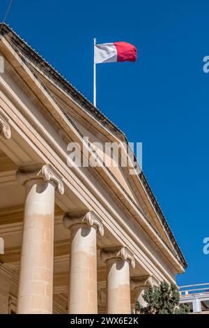 Le drapeau maltais flotte sur le bâtiment des cours de justice dans le centre historique de la Valette, Malte Banque D'Images