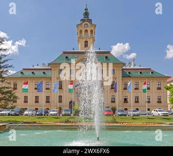 Szeged, Hongrie - 16 juin 2021 : Fontaine d'eau Parc de la place Szechenyi en face du bâtiment de la mairie. Banque D'Images