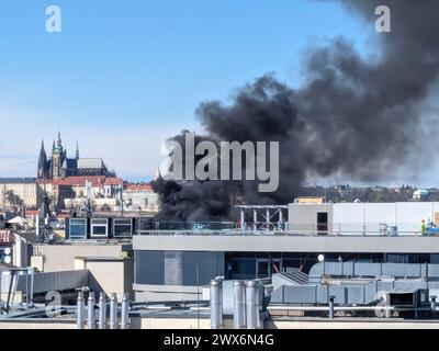 Prague, République tchèque. 28 mars 2024. Une fumée épaisse s'élève d'un bloc intérieur d'un bâtiment dans la partie centrale de la place Venceslas à Prague, en République tchèque, le 28 mars 2024. Les pompiers se rendent sur les lieux, selon les premières informations, le feu brûle sur le chantier de construction. Sur la gauche en arrière-plan est vu le château de Prague. Crédit : Radka Matesova Markova/CTK photo/Alamy Live News Banque D'Images