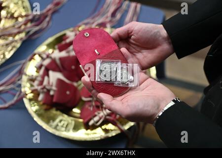 Sacs à main rouges qui contiennent une pièce de 5 £ représentant l'image d'un dragon Tudor et du roi Charles III, et une pièce de 50p commémorant la RNLI, que la reine Camilla distribuera pendant le service Royal Maundy à la cathédrale de Worcester. Date de la photo : jeudi 28 mars 2024. Banque D'Images