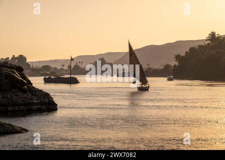 Felucca (bateau à voile égyptien traditionnel) sur le Nil au coucher du soleil à Assouan, Egypte Banque D'Images