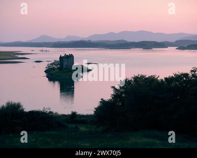 Château Stalker au coucher du soleil à Argyll, Écosse Royaume-Uni. Il est situé sur un îlot de marée sur le Loch Laich, une crique au large du Loch Linnhe. Paysage écossais Banque D'Images