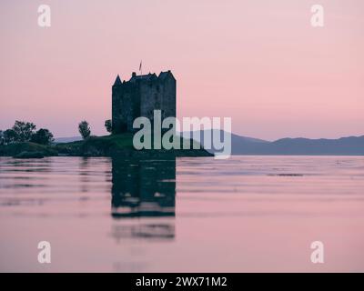 Château Stalker au coucher du soleil à Argyll, Écosse Royaume-Uni. Il est situé sur un îlot de marée sur le Loch Laich, une crique au large du Loch Linnhe. Paysage écossais Banque D'Images