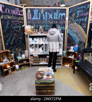 Marché aux puces. Jeune femme debout devant un comptoir avec des choses anciennes et des souvenirs, en choisissant un. 26 septembre 2019. Kiev, Ukraine Banque D'Images